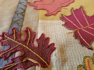 Appliqueing fall leaves onto quilt