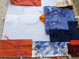 Composing a fabric collage in blue and orange